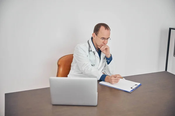 Концентрированный медицинский работник работает в своем офисе — стоковое фото