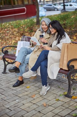 Sokakta tablet bilgisayar kullanan güzel bayan arkadaşlar.