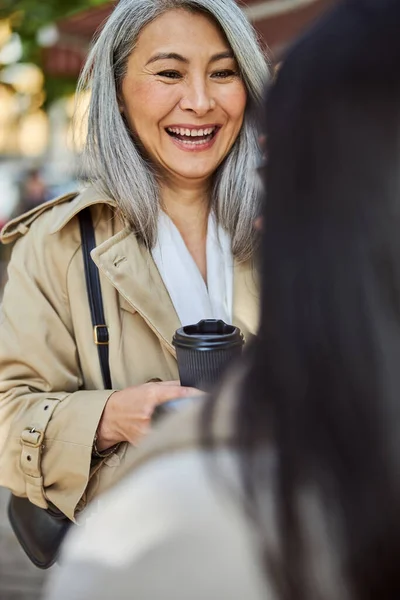 Glada kvinna talar med vän på gatan — Stockfoto