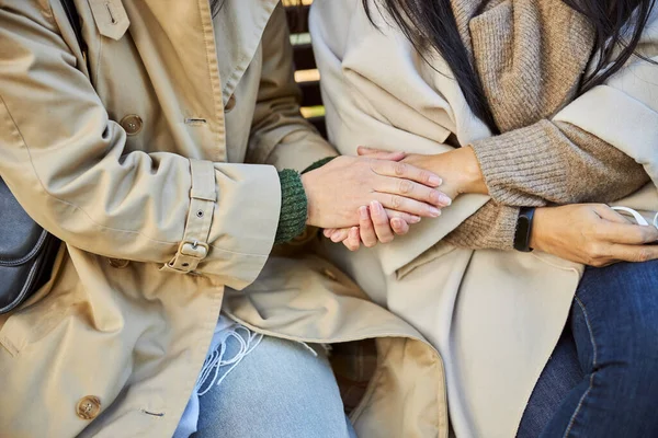 Female friends holding hands on the street