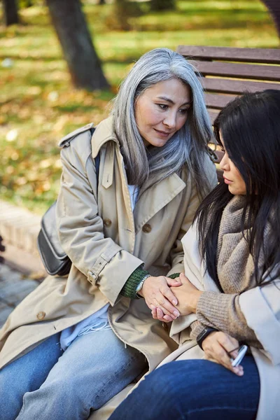 Caring woman holding hand of sad friend on the street — Stock Photo, Image