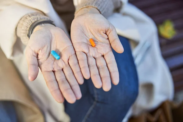 Mujer sosteniendo cápsulas de drogas azul y naranja —  Fotos de Stock