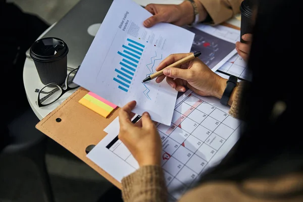 Geschäftspartner analysieren Diagramme und Grafiken im Outdoor-Café — Stockfoto