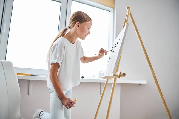 Smiling amateur artist painting on the canvas — Stock Photo, Image