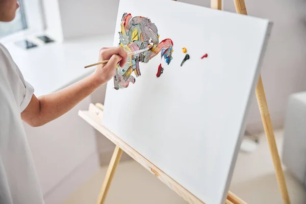 Junge Malerin zeichnet auf der Staffelei — Stockfoto
