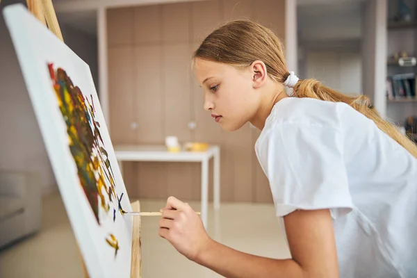 Ernstes Mädchen mit Pferdeschwanz zeichnet ein Bild — Stockfoto