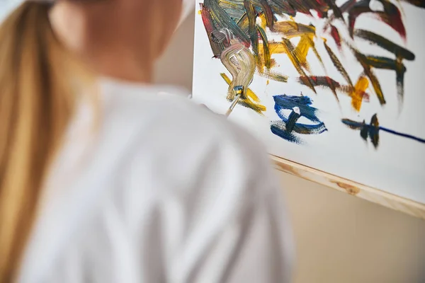 Chica con una pintura de cola de caballo con un pincel — Foto de Stock