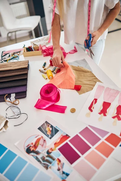 Dressmaker in piedi al tavolo da taglio nel suo studio — Foto Stock