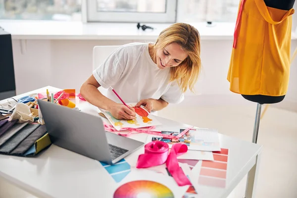 Uśmiechnięty projektant mody szkicuje ołówkiem — Zdjęcie stockowe