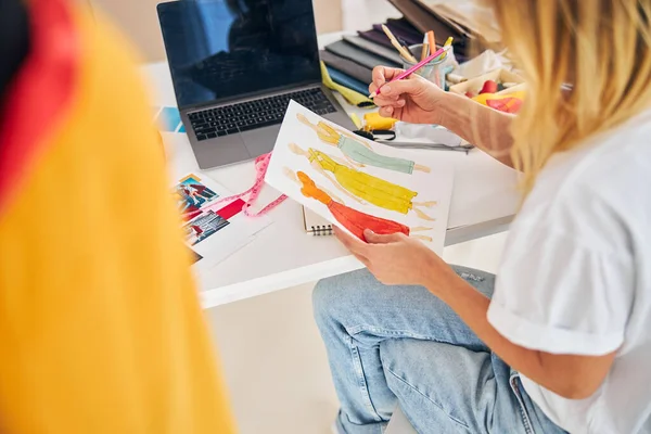 Bionda stilista donna guardando i suoi disegni — Foto Stock