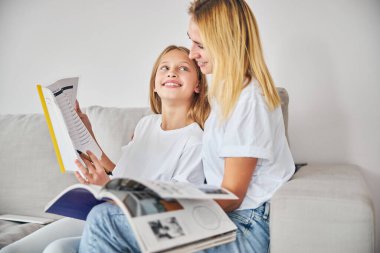 Görevini bitirdikten sonra gururla annesine bakan bir kız.