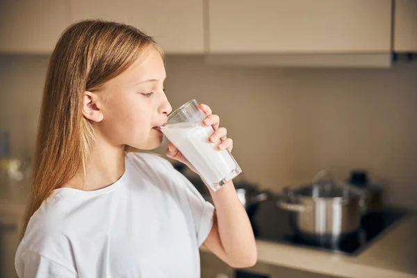 Dlouhovlasá dívka pije zdravý mléčný nápoj — Stock fotografie