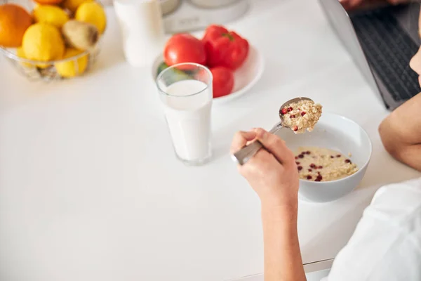 Skolflicka äter frukost vid köksbordet — Stockfoto