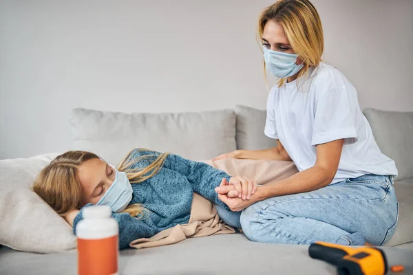 Mãe amorosa cuidando de seu filho feminino doente — Fotografia de Stock