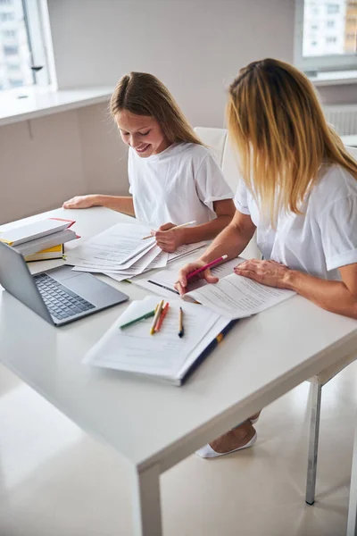 Kvinna hjälper en tonåring med sina engelska övningar — Stockfoto