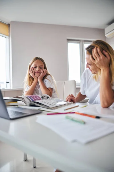 Uninterested pupil giving a look at a boring grammar textbook — Stock Photo, Image