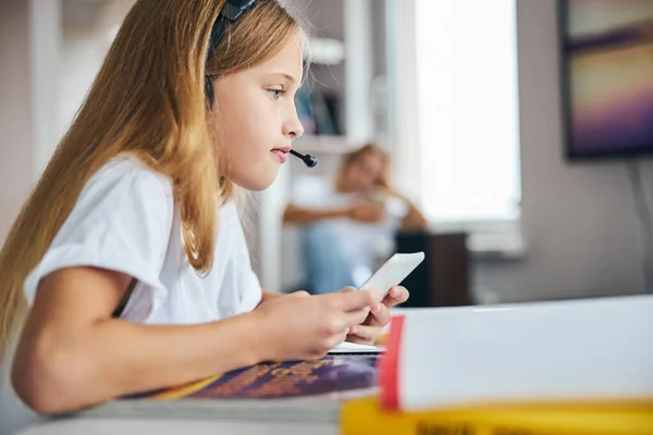 Nastolatka pisząca na komórkę przy biurku — Zdjęcie stockowe
