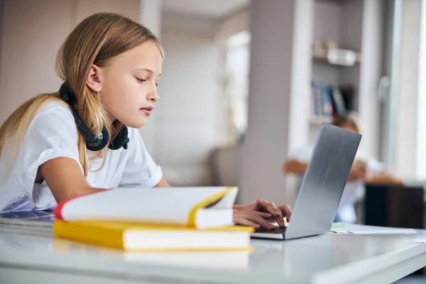 Teenager-Mädchen tippt auf einer Laptop-Tastatur — Stockfoto