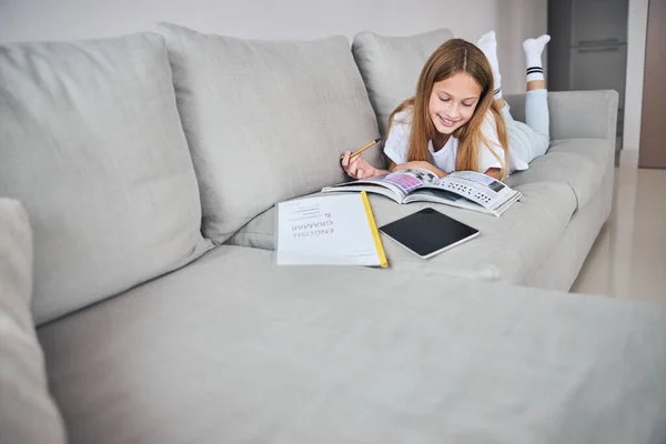 Minor studying with her feet in the air — Stock Photo, Image