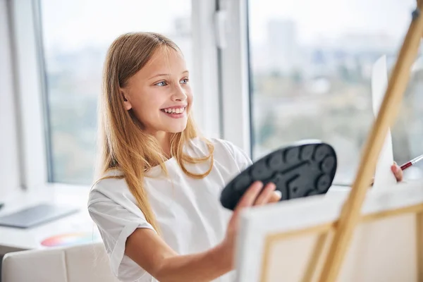 Щаслива школярка оцінює твори мистецтва в руці — стокове фото