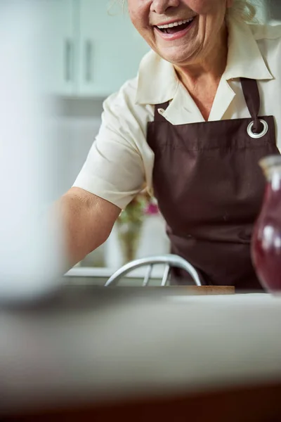 Allegro vecchia donna che esprime emozioni positive in cucina — Foto Stock