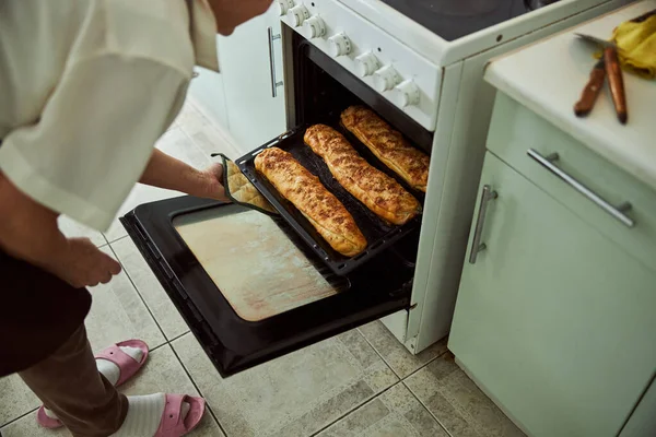 Gammal kvinna bakar köttpajer i köket hemma — Stockfoto
