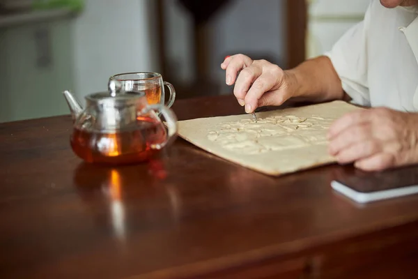 Mujer anciana haciendo imagen de arcilla polimérica en casa — Foto de Stock