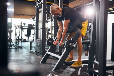 Neşeli sporcu adam kaslarını geliştiriyor.