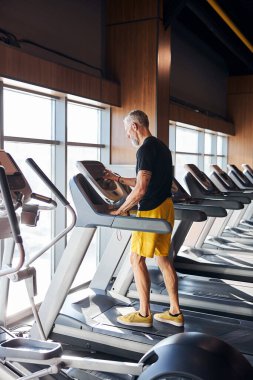 Koşu bandındaki kontrol panelini kuran adam.