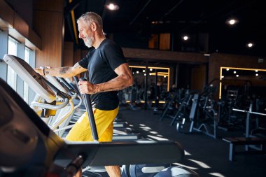 Spor salonunda kardiyo antrenmanı yapan ciddi bir sporcu.