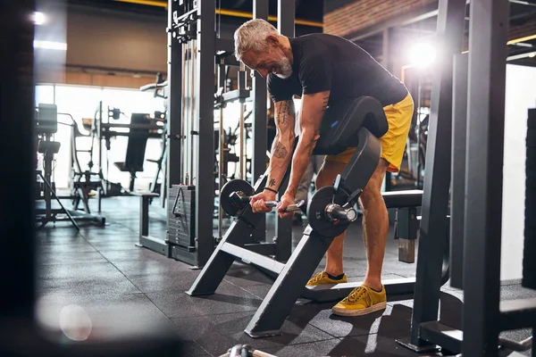 Fröhlicher sportlicher Mann baut seinen Bizeps auf — Stockfoto