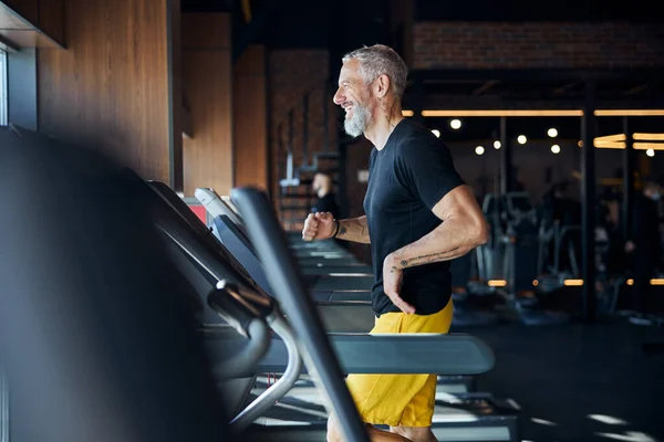 Atlet Kaukasia yang riang berlari di atas treadmill — Stok Foto