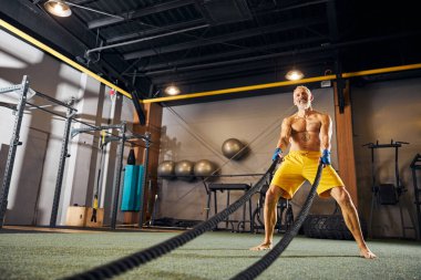 Neşeli erkek sporcu kol kaslarını güçlendiriyor.