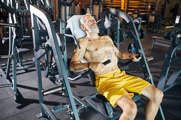 Профессиональный спортсмен наращивает мышцы на тренажере — стоковое фото