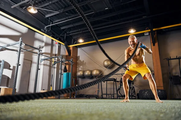 Fröhlicher grauhaariger Athlet beim intensiven Training — Stockfoto