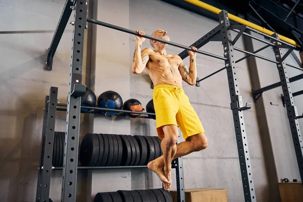 Atleta masculino fazendo pull-ups no ginásio — Fotografia de Stock