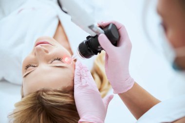 Profesyonel kadın dermatolog güzellik ameliyatı yapıyor.