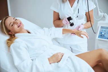 Kozmetik ameliyatı sırasında gülümseyen sarışın kadın.