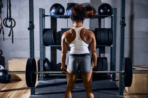 Mujer deportiva fuerte haciendo el ejercicio de levantamiento de pesas — Foto de Stock