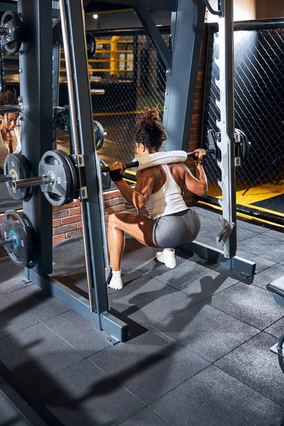 Treinador de fitness executando a barra de volta agachamentos — Fotografia de Stock