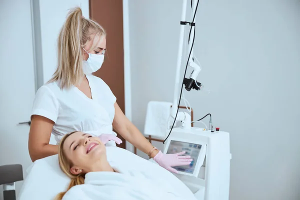 Dermatólogo tocando la pantalla de una máquina de belleza — Foto de Stock