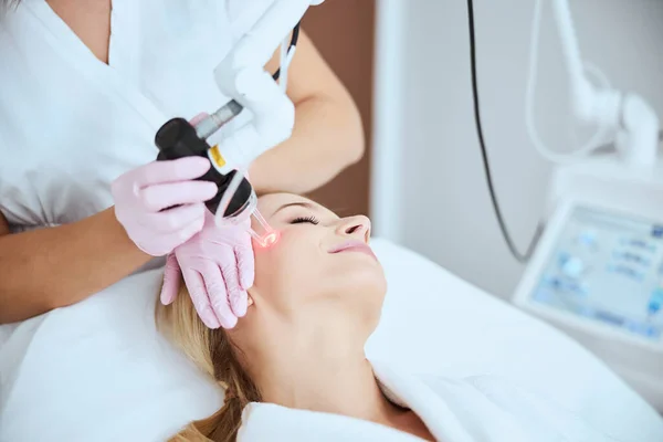 Mujer joven sometida a un procedimiento cosmético no invasivo — Foto de Stock