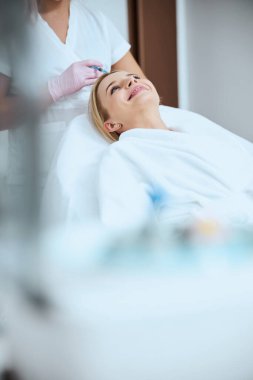 Hasta, trombosit zengini plazmayı kafa derisine enjekte ediyor.