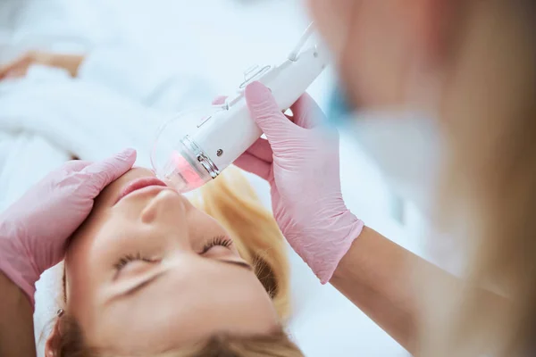 Лікар використовує апаратну косметологію для лікування свого пацієнта — стокове фото