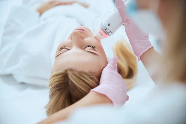 Dermatoloog behandelen van haar patiënt met een beauty device — Stockfoto