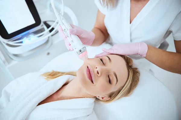 Sonriente mujer relajada disfrutando del procedimiento cosmético —  Fotos de Stock