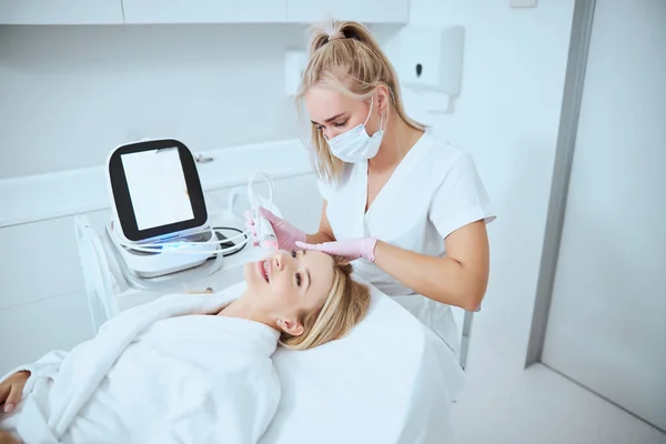 Mujer sonriente recibiendo un tratamiento facial de la piel —  Fotos de Stock