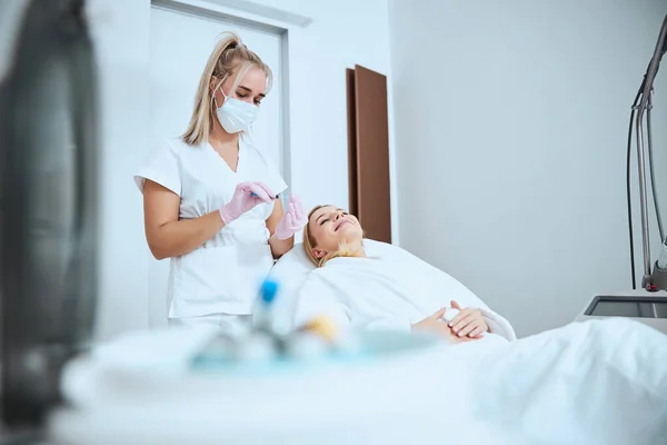 Doctor withdrawing the serum from the tube into the syringe — Stock Photo, Image