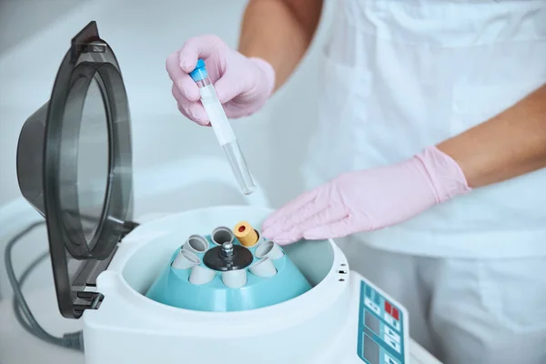 Опытный дерматолог готовит сыворотку с использованием медицинского оборудования — стоковое фото