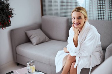 Girişteki kanepede oturan neşeli çekici hasta.